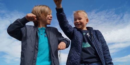 To glade drenge med armene i vejret