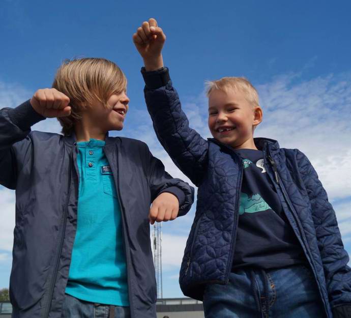 To glade drenge med armene i vejret